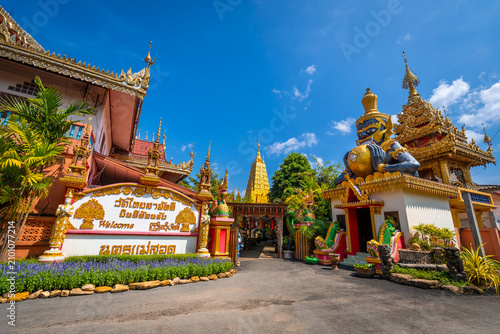 Foto Beautiful entrance of Wat Thai Samakkhi temple in Mae Sot, Tak, Thailand, featuring a giant Rahu deity statue and a golden pagoda