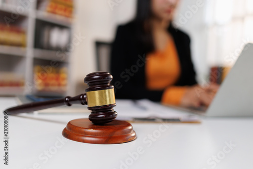 Bild auf Leinwand Gavel and laptop on white desk with a blurred lawyer or legal professional worki