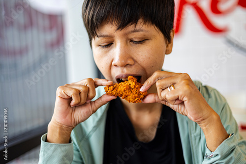 Konstfotografi Asian woman eating crispy fried chicken