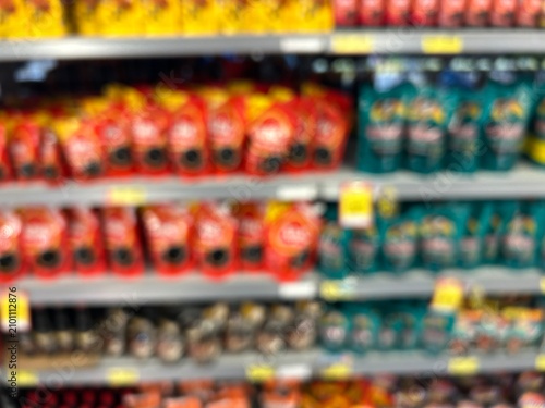 Blurred background of supermarket shelves filled with food pouches and refill packaging