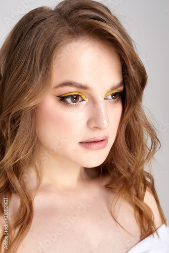 A beautiful female portrait with perfect makeup is depicted on a white background.