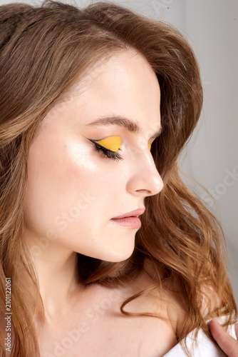 A beautiful female portrait with perfect makeup is depicted on a white background.