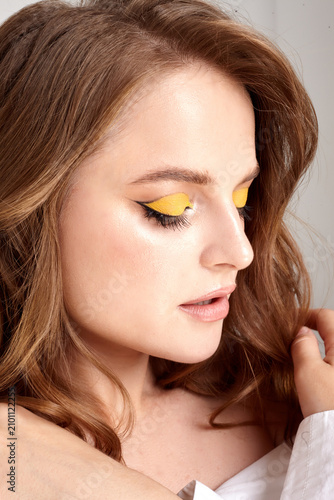 A beautiful female portrait with perfect makeup is depicted on a white background.