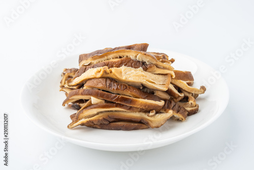 A dish of sliced ​​shiitake mushrooms on a white background.