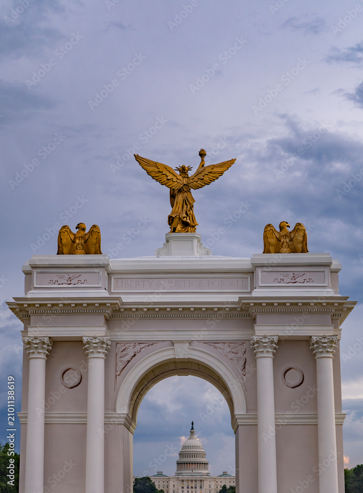 Obraz premium Capitol view through patriotic arch. Historic Capitol view with statue. Ceremonial Capitol view honors America. Capitol view under cloudy sky.