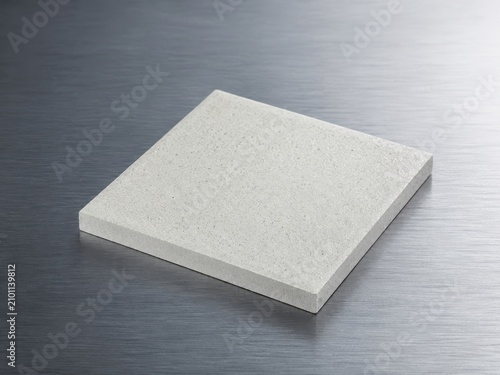 Minimalist ceramic slab on metal surface with precise engineering detail and professional studio lighting
