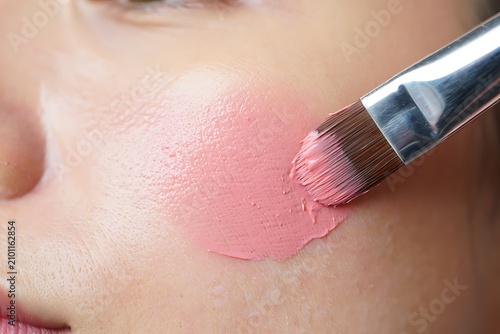 Applying blush with makeup brush on skin