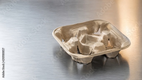Minimalist drink carrier on metal surface with precise engineering detail and professional studio lighting