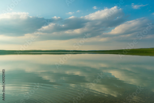 Calm lake water, serene landscape, blue sky, reflection, nature scenery