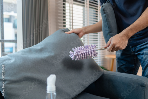Professional home and office cleaning with disinfecting spray, wiping shelves, dusting furniture and sanitizing sofa surfaces to maintain a clean, organized and healthy indoor environment.