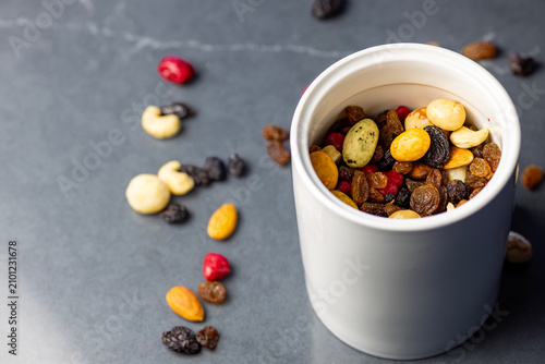 Mixed Nuts Dried Fruit Seeds in White Ceramic Jar on Dark Background