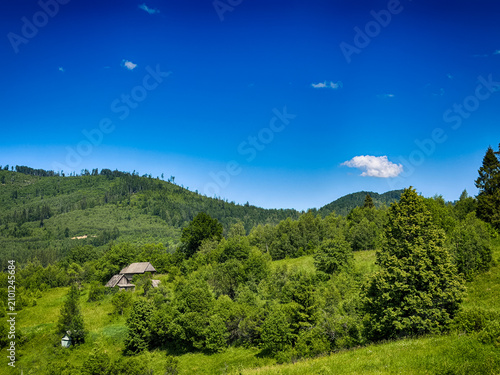 Sunny Carpathian peaks: green valleys and cloudy skies.