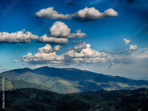 Sunny Carpathian peaks: green valleys and cloudy skies.