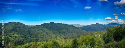 Sunny Carpathian peaks: green valleys and cloudy skies.
