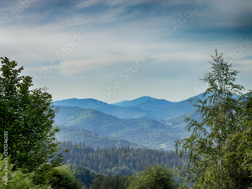 Sunny Carpathian peaks: green valleys and cloudy skies.