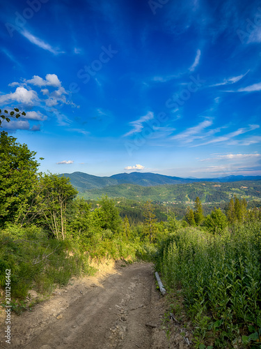 Sunny Carpathian peaks: green valleys and cloudy skies.