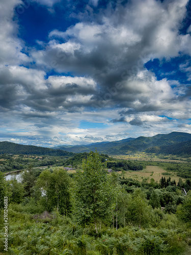 Sunny Carpathian peaks: green valleys and cloudy skies.