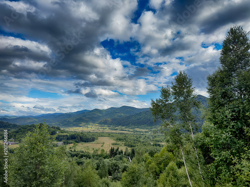 Sunny Carpathian peaks: green valleys and cloudy skies.