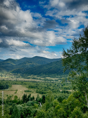 Sunny Carpathian peaks: green valleys and cloudy skies.