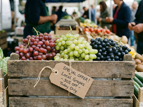 Mix of Red Green and Purple Grapes in Crate with Special Offer Discount Tag at Market