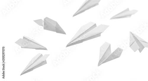 Bild auf Leinwand Multiple white paper airplanes flying in different directions against a white ba