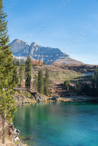 Lake Careza with its turquoise blue color, surrounded by mountain peaks and forest. South Tyrol, Italy.