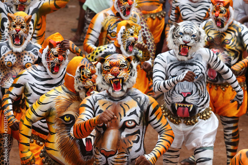 Tiger dance performers in vibrant tiger body paint and elaborate masks parade during the Onam festival in Thrissur, Kerala, India, celebrating a renowned traditional folk art