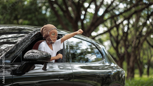Quadro su tela Little Boy Wearing Vintage Aviator Helmet Leaning Out of Car Window, Pretend Fly