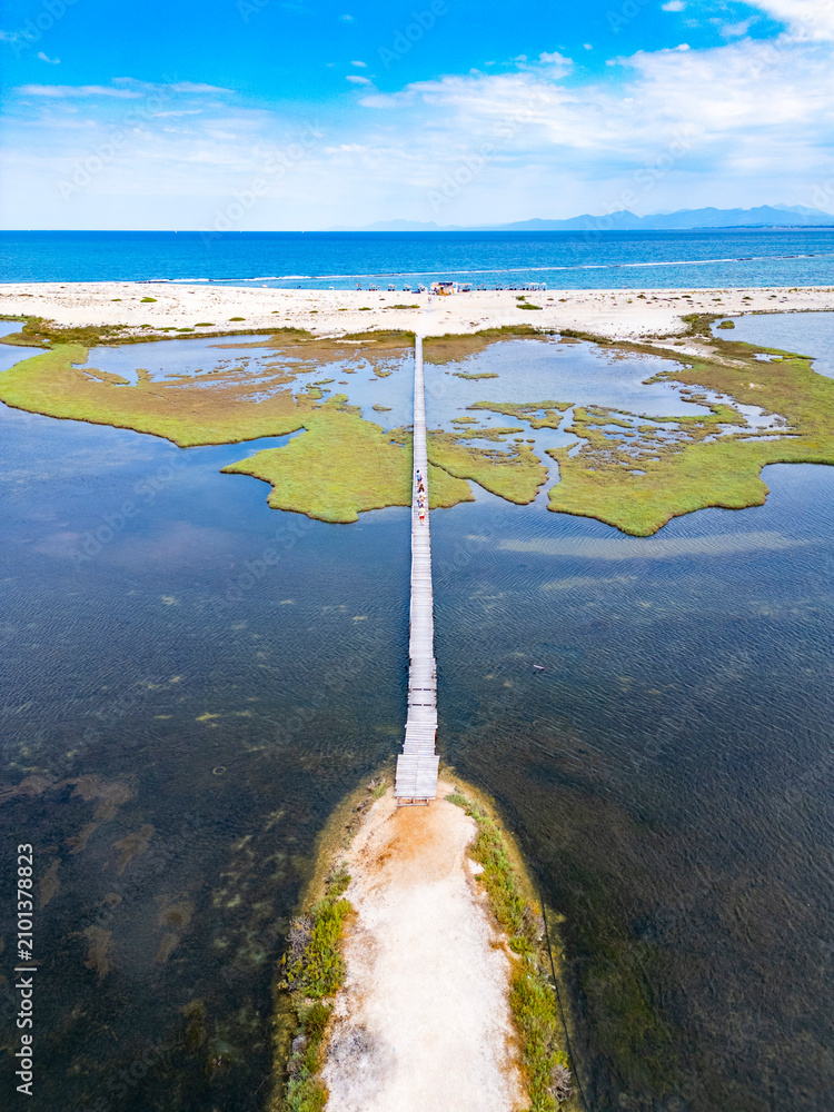 Fototapeta premium Wooden pier crossing saltwater lagoon towards ionian sea
