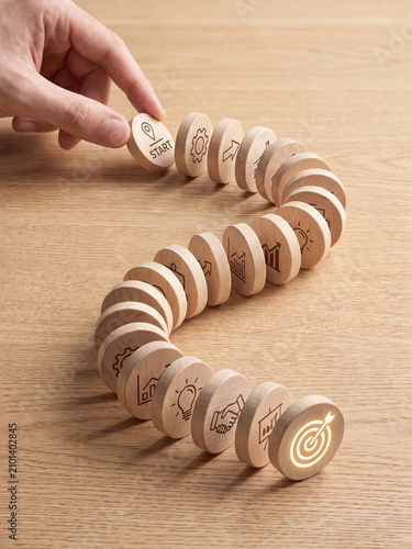 Business strategy and goal achievement concept with wooden dominoes arranged in a path
