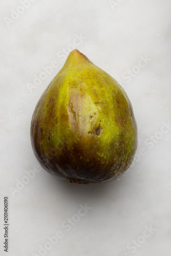 Macro detail of a ripe fresh fig on a marble background, highlighting its delicate skin, natural texture, and Mediterranean appeal in an elegant food composition.