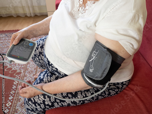 Quadro su tela Senior Woman Measuring Blood Pressure With Digital Monitor at Home