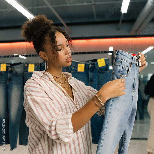 Woman Shopping for Blue Jeans in Modern Clothing Store