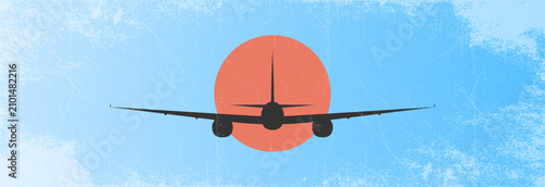 Airplane silhouette flying across the large red sunset sun.