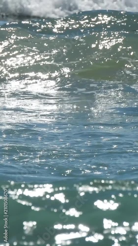 Sea waves splashing on sunny day, vertical video