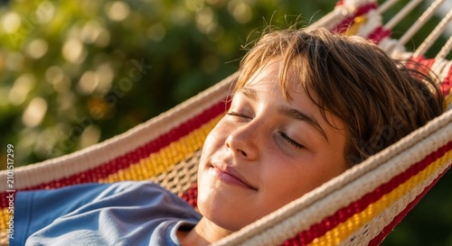 Boy relaxing in hammock enjoying sunshine outdoors. Peaceful moment captured with boy in hammock surrounded by nature. Ideal scene for children's products, summer activities, or relaxation themes.