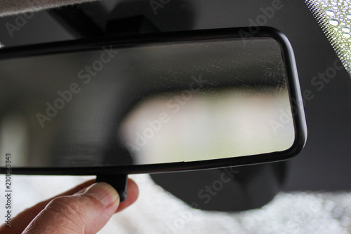 Hand adjusting a basic anti-dazzle rear view mirror