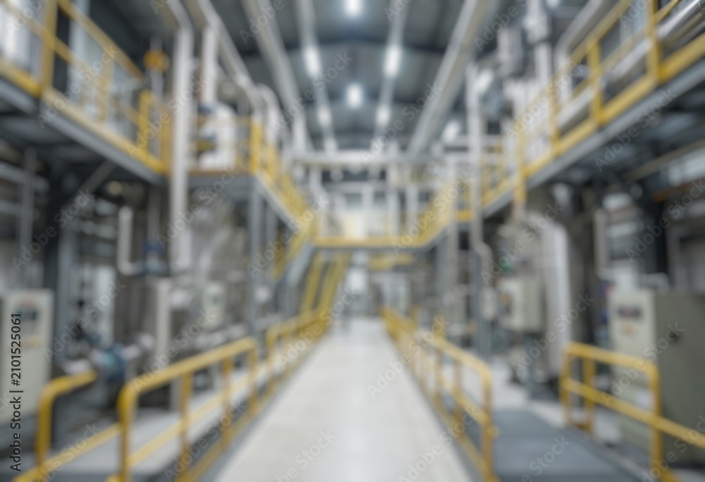 Fototapeta premium Defocused factory interior featuring industrial motors, piping systems, and mechanical equipment for production processes.