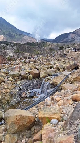 Steaming geothermal landscape at Mount Papandayan with rocky volcanic terrain.