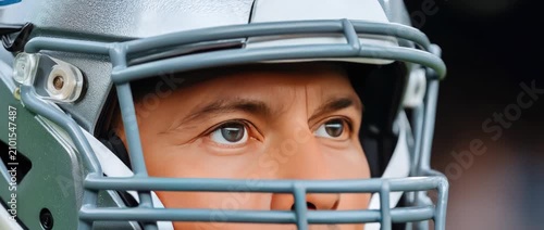 Close look at a player wearing a helmet during a football game at a stadium in the afternoon