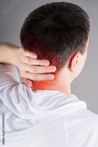 Close up of man holding painful neck and back of head with red highlighted spot, cervicogenic headache or cervical osteochondrosis concept