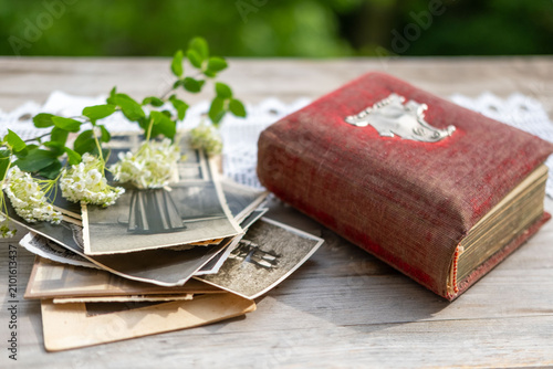 Vintage family photo album cover with white lace tablecloth next to dried flowers wooden box evoking nostalgia heritage, Antique memorabilia book preserved history and cherished ancestral memories