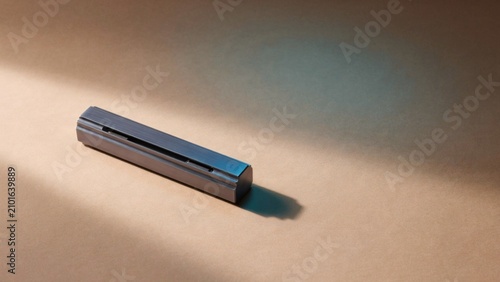 A single metal stamping block on a brown surface with dramatic lighting and shadow.