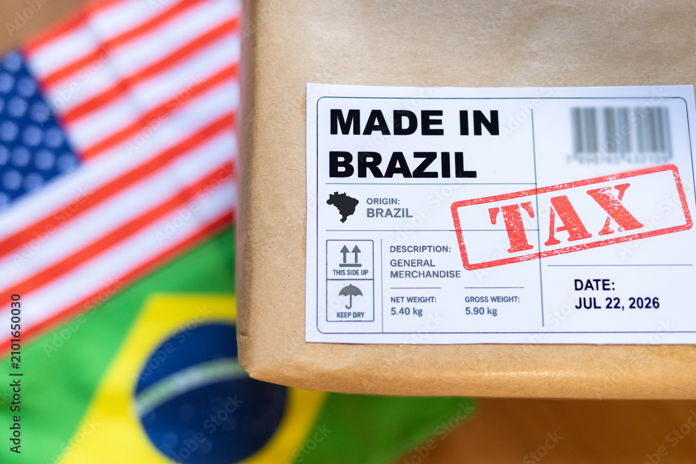 Fototapeta premium Package labeled “Made in Brazil” with a tax stamp and blurred Brazilian and U.S. flags, representing tariffs on Brazilian exports to the United States.