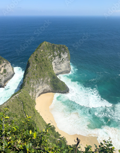 Foto Iconic T-Rex-shaped limestone headland and white sand cove with turquoise waves at Kelingking Beach, Nusa Penida, Bali, Indonesia