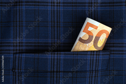 Fotografie Fifty euro banknote sticking out of a blue plaid pocket, symbolizing savings, finance, or hidden money