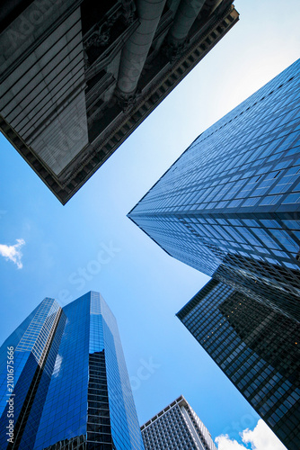 Downtown Manhattan skyscrapers. Low angle view of modern glass financial district towers rising into blue sky in NYC.