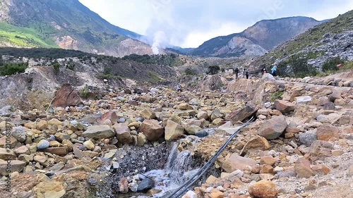 Rocky volcanic landscape with steaming geothermal vents at Mount Papandayan.