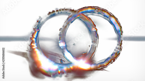 Two glowing rings intertwined, radiating light against black