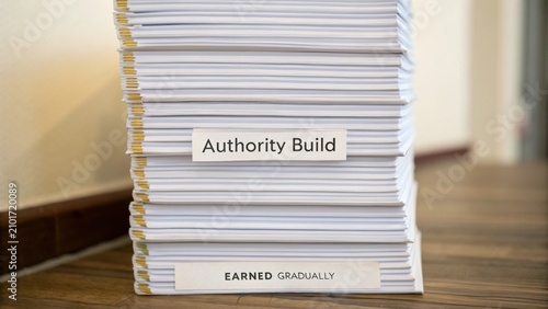 Stack of Organized Documents Indicating Concept of Authority Build and Earned Gradually in Professional Development Context